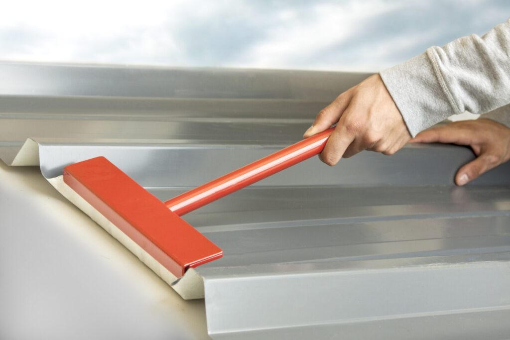 Le couvreur plie l'onde du bac acier.